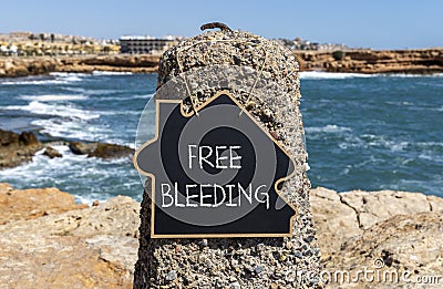 Free bleeding symbol. Concept words Free bleeding on beautiful black chalk blackboard. Beautiful stone sea blue sky background. Stock Photo