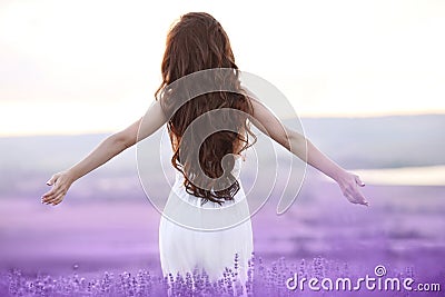 Free brunette woman with open arms enjoying sunset in lavender f Stock Photo