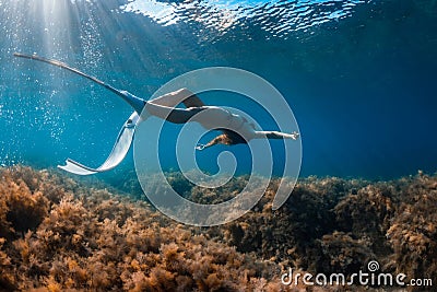 Free diver with white fins posing underwater. Freediving with young girl Stock Photo