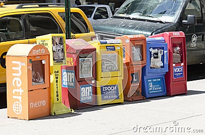 Free newspaper dispensers in a street of Manhattan Editorial Stock Photo