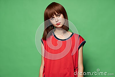 Sad woman tilted her head to the side against a green background free place Stock Photo