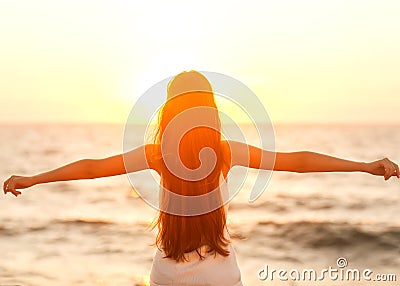 Free woman enjoying freedom feeling happy at beach at sunset. Be Stock Photo