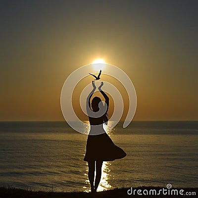 Freedom concept with silhouette of bird flying out of woman hands Stock Photo