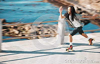 Freedom, energy and roller skating with black man training and exercise along a beach outdoors. Active African American Stock Photo