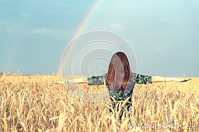 Freedom. Happy smiling woman with open hands in wheat field with Golden spikelets looking up at the sky on rainbow background Stock Photo