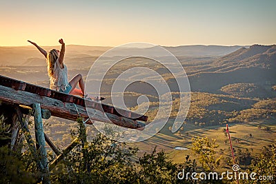 Freedom loving woman feeling exhilaration on ramp high above the valley Stock Photo