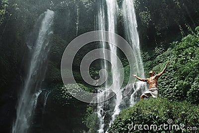 Freedom. Man Feeling Free With Hands Up Near Waterfall Stock Photo