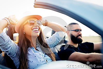 Freedom of the open road.Young Couple Driving Along Country Road In Open Top Car Stock Photo