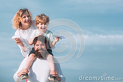 Freedom to dream - joyful boy playing with toys airplane against the sky - vintage effect. Happy father giving shoulder Stock Photo