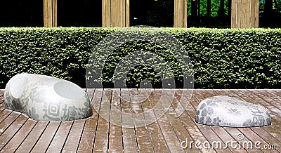 Freeform stone seating on wood terrace in the garden Stock Photo