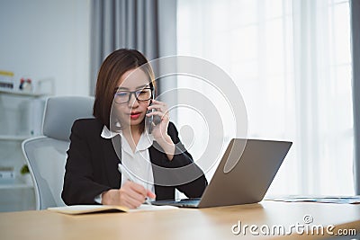 Freelance business woman calling on mobile smartphone while working with laptop, businesswoman mobile phone to calling with Stock Photo