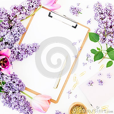 Freelancer or blogger workspace with clipboard, notebook, pen, lilac, and tulips on white background. Flat lay, top view. Stock Photo