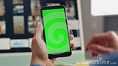 Freelancer finger scrolling greenscreen smartphone closeup. Man mockup cellphone Stock Photo