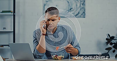 freelancer holding plastic fork and eating Stock Photo