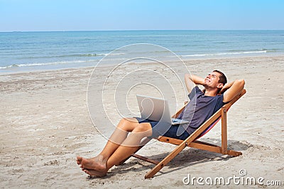 Freelancer with laptop on the beach, successful happy business man relaxing Stock Photo