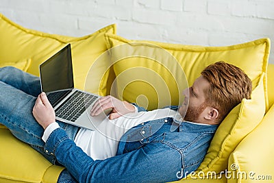 Freelancer man working on laptop while lying Stock Photo