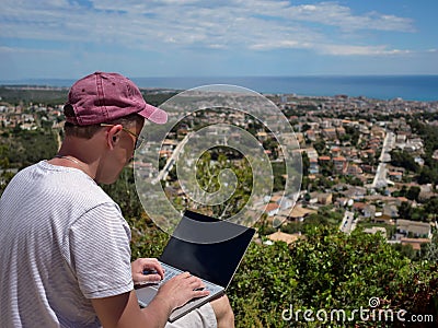 Freelancer, a man works in nature, with a beautiful landscape in front of him, work in pleasure Stock Photo