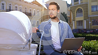 Freelancer sending laptop email and swinging stroller, family and career balance Stock Photo