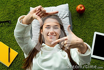 Freelancer taking photo, lying on green carpet Stock Photo