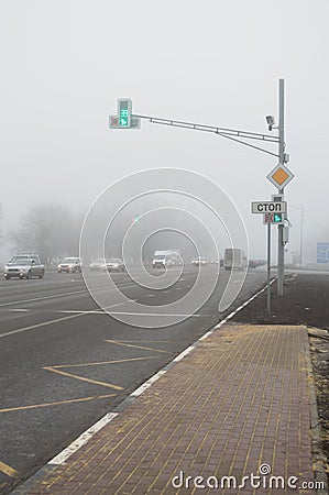 Freeway and intersection with traffic lights in dense fog Editorial Stock Photo