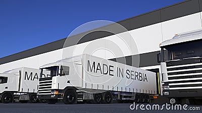 Freight semi trucks with MADE IN SERBIA caption on the trailer loading or unloading. Road cargo transportation 3D Stock Photo
