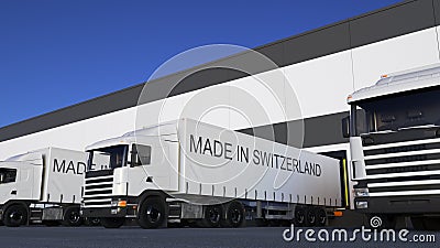 Freight semi trucks with MADE IN SWITZERLAND caption on the trailer loading or unloading. Road cargo transportation 3D Stock Photo