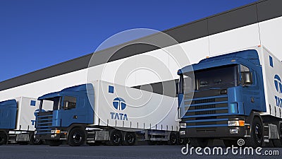 Freight semi trucks with Tata Group logo loading or unloading at warehouse dock. Editorial 3D rendering Editorial Stock Photo