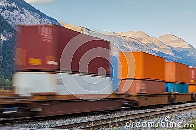 Freight cargo train passing mountains Stock Photo