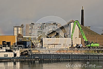 Freighter in front of old industrial buildings and apartment block in the old port of Ghent Editorial Stock Photo