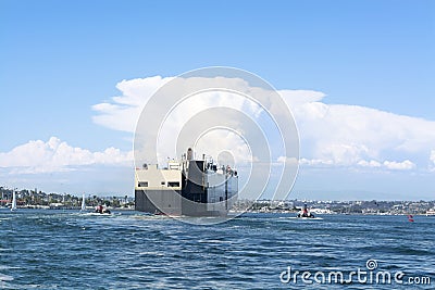 Freighter guided by tugboats Stock Photo