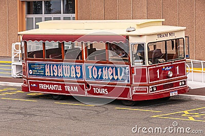 Fremantle, Australia - November 25. 2009: Maroon tour tram called Highway to Hell parked in front of borwn building waits for Editorial Stock Photo