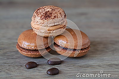 French Chocolate & Coffee Macaroons And Coffee Beans, Tasty Gormet Meringue Cookie Sandwich Cake on Vintage Wood Background Stock Photo