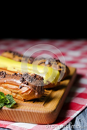 French eclairs with choclate top and different fillings. Traditional recipe, French cuisine. Stock Photo