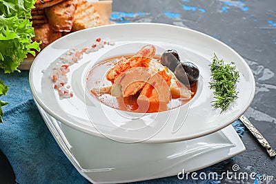 French fish soup Bouillabaisse with seafood, salmon fillet, shrimp, rich flavor, delicious dinner in a white beautiful Stock Photo