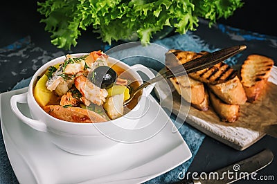 French fish soup Bouillabaisse with seafood, salmon fillet, shrimp, rich flavor, delicious dinner in a white beautiful Stock Photo