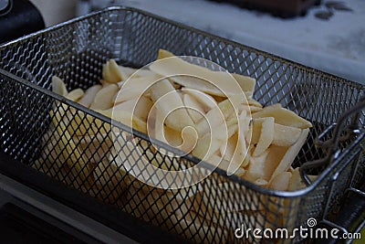 French fries in the fryer, ready to be plunged in oil Stock Photo