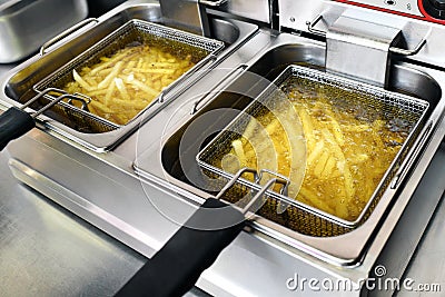 French fries or potato chips frying in oil Stock Photo