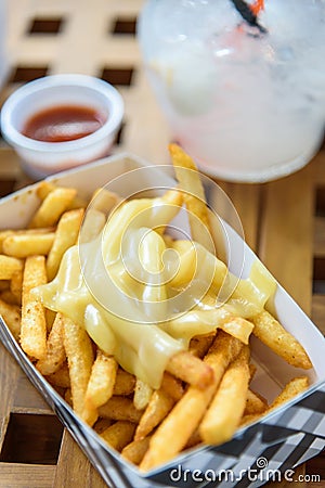 French Fries on Toping Cheese in Paper Box. Stock Photo