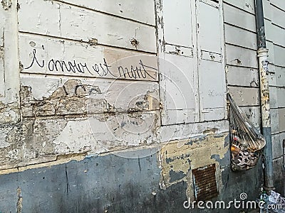 French graffiti on scruffy wall says Love is dead Editorial Stock Photo