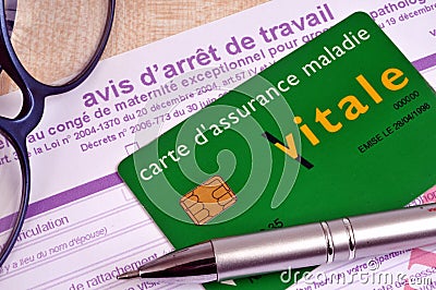 French health insurance card placed on a work stoppage form next to glasses and a pen Editorial Stock Photo