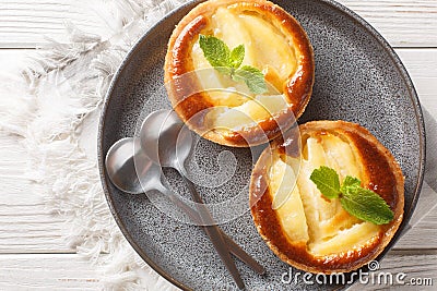 French portioned Apple tartlets decorated with mint close-up in a plate. Horizontal top view Stock Photo