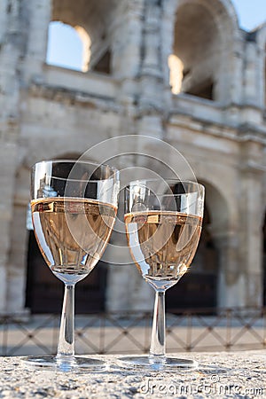 French rose dry wine from Provence in two glasses in sunny day with view on old streets of Arles town in sunny day Stock Photo