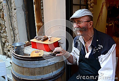 French seller invites tourists to taste sausages Editorial Stock Photo