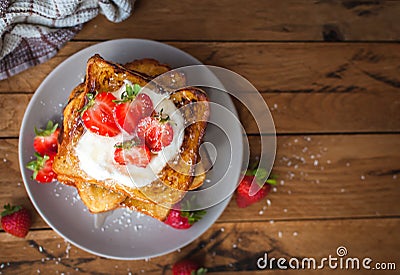 French toast with fresh strawberries, coconut shreds and honey, on wooden background, top view, text space, copy space Stock Photo