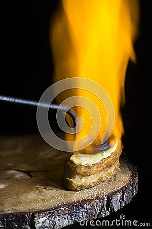 French toast topped with cream and sugar and flamed with an incandescent iron in the traditional style. large flame of fire. Stock Photo