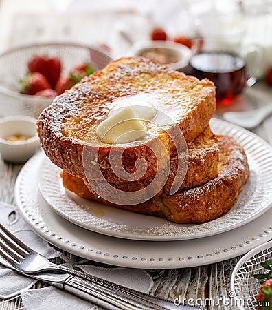 French toast, warm French toast made of sliced brioche with fresh butter, sprinkled with powdered sugar. Stock Photo