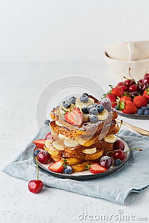 French toasts with berries and banana, brioche breakfast, white background vertical closeup Stock Photo