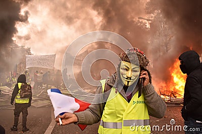 French Yellow Vest Protestor wearing Guy Fawkes mask at a Demonstration in Paris Editorial Stock Photo