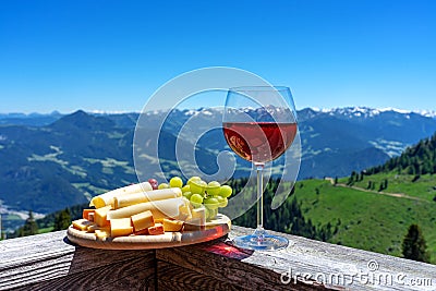 fresch tirol cheese with wine and grapes over mountain landscape Stock Photo