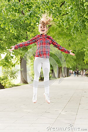 Fresh air gives her the vital energy. High energy or hyperactive kid. Small girl jumping in casual fit for energetic Stock Photo